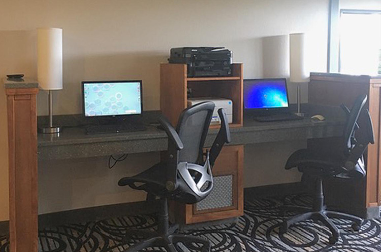 Two work stations with desktops and swivel chairs
